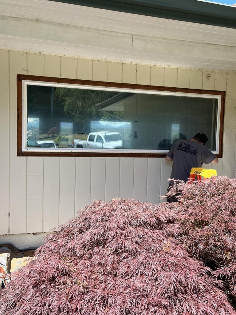 Groves Glass installer sealing new glass panel during replacement in Poulsbo WA
